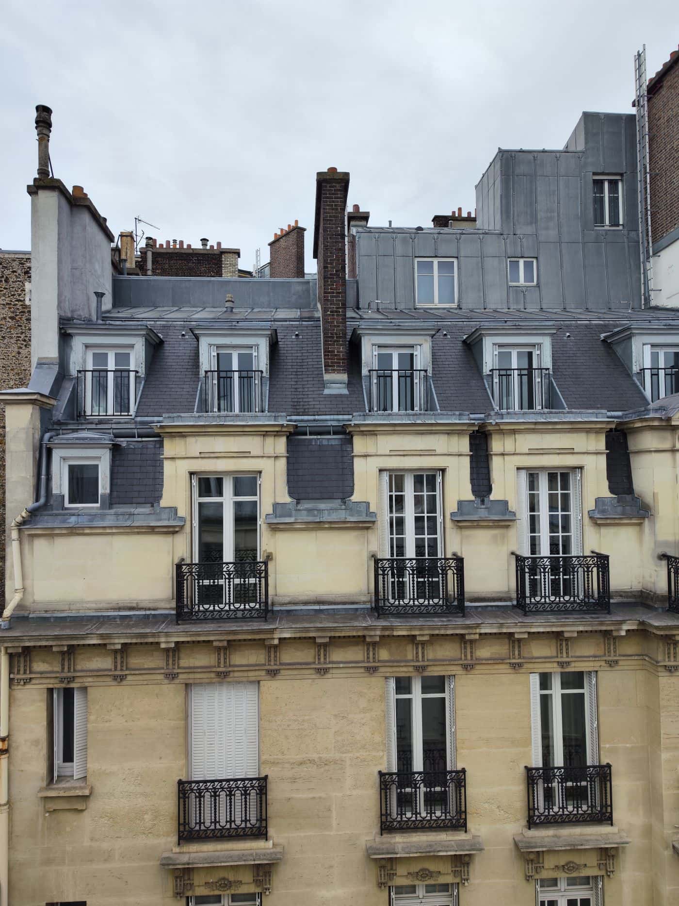 Une façade d'immeuble haussmannien avec ses balcons en fer forgé